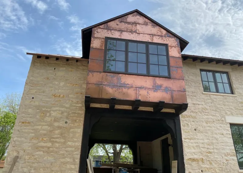 Copper metal panel facade on a stone building for Skylight Installation in Elon
